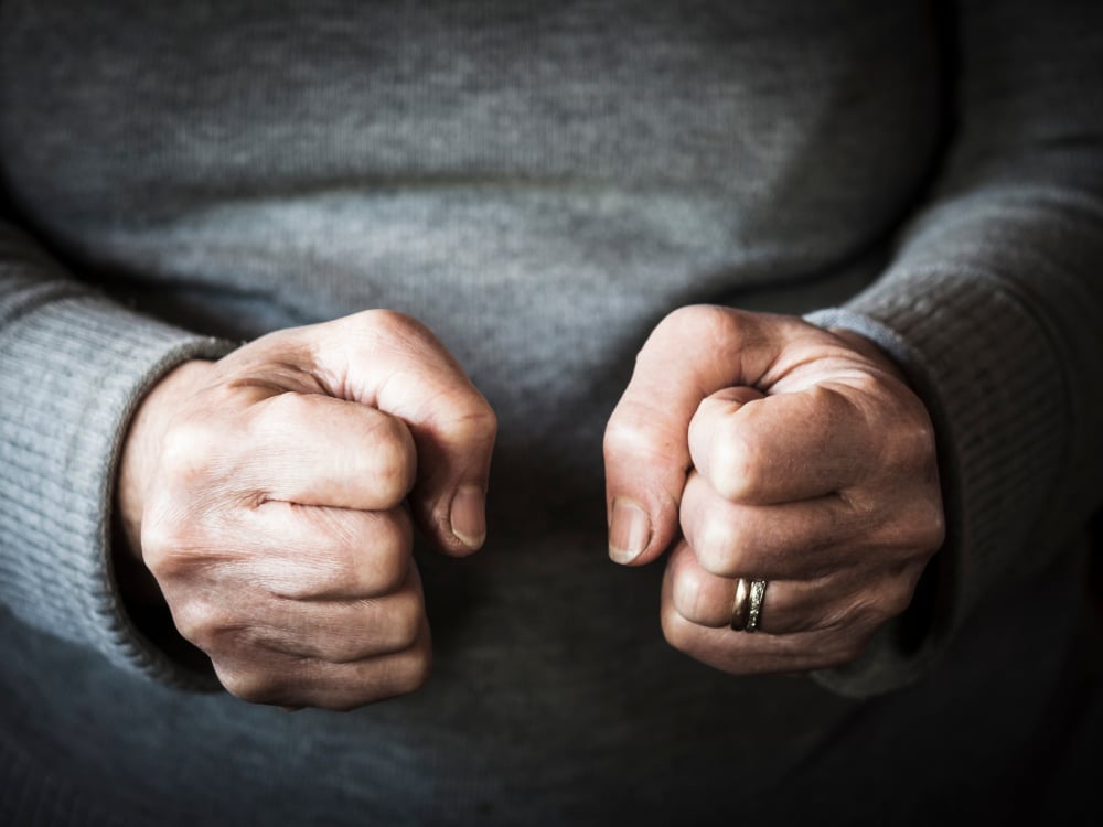 Leer woede beheersen met Hypnotherapie 2 Twee gebalde vuisten voor een grijze trui.