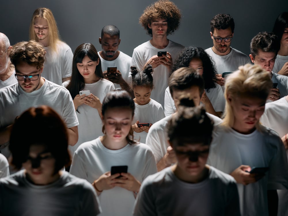 Verslaving stoppen met Hypnotherapie 2 Een groep mensen kijkt naar mobiele telefoons.